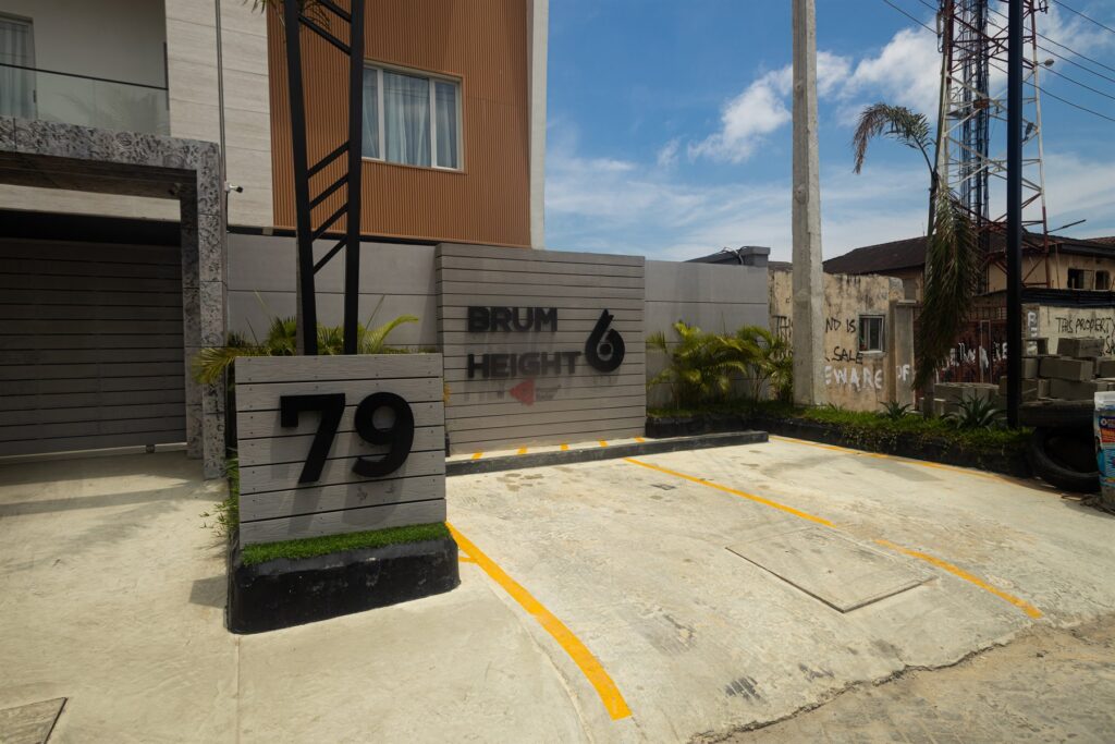 Brum Height 6: Entrance forecourt and development sign beside landscaping